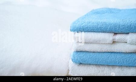 Pila di asciugamani in blu e bianco su bianco della neve, isolata. Blu classico colore dell'anno 2020. Foto Stock