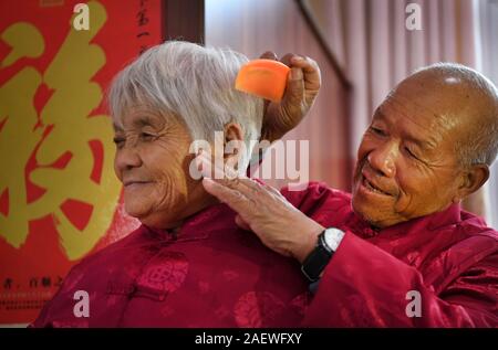 (191211) -- PECHINO, Dic 11, 2019 (Xinhua) -- Zhang Jinshui (R) pettini capelli per il suo nuovo sposa Guo Dangcun a geracomium in Luonan County, Cina nord-occidentale della provincia di Shaanxi, Ottobre 15, 2019. Zhang Jinshui, 71 e Guo Dangcun, 73, sono un neo-sposa giovane che vive in un alloggiamento geracomium local indigenza degli anziani. Guo Dangcun perse la vista anni fa a causa di malattia e girato incommunicative sotto lo sciopero del decesso dell'ex marito. Negli ultimi anni, Zhang Guo ha contribuito con la sua vita quotidiana e riacquistare la fiducia e la felicità. Essi ufficialmente sposato su Oc Foto Stock