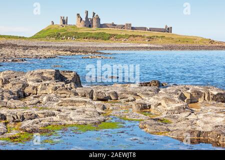 Il castello di Dunstanburgh, una trecentesca fortificazione è situato sulla costa del Northumberland in Inghilterra settentrionale. Foto Stock