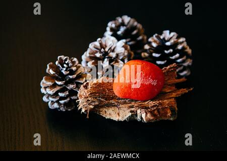 Sfondo di Natale italiano Buon Natale, naturale Xmas decorazione, pigne su legno rustico Foto Stock