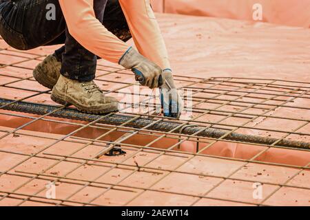 Australian builder acciaio esegue operazioni di fissaggio con l'attrezzo di legatura per una nuova casa suburbana lastra Foto Stock