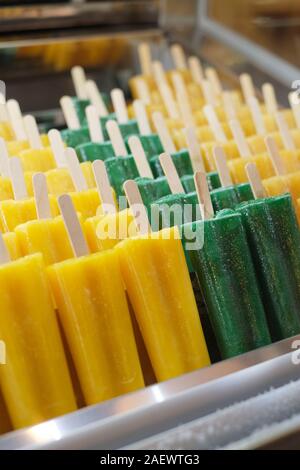 Naturali freschi di Puro succo di frutta aromatizzato ghiaccioli su bastoni di legno per la vendita in un contatore di freezer - gelato - ice popsicles - ice pops - aromi Foto Stock