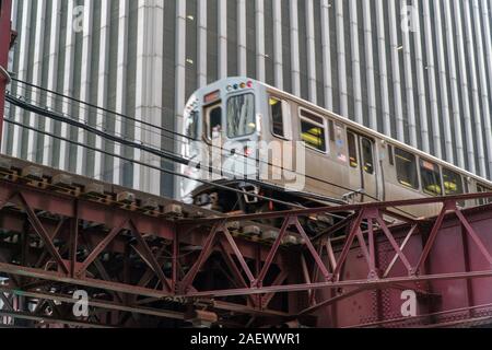 Il giorno che istituisce il colpo di Chicago L treno passa dal centro cittadino di edificio per uffici sulle vie aeree elevate carreggiata. Foto Stock