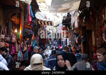 Mercato di strada piena di persone per le strette stradine della medina di Fez, Marocco Foto Stock