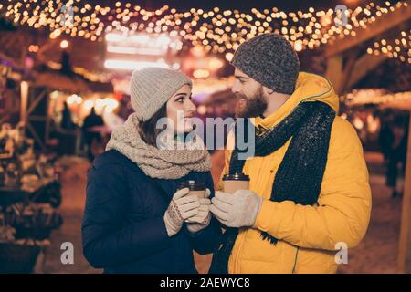 Foto di due persone carino coppia guy lady con bevanda calda nelle mani X-mas eve dedicare tempo a terra magica newyear shopping market Scegli regali genitori Foto Stock