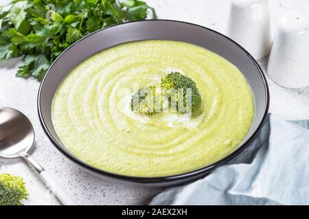 Broccoli cream soup nella ciotola sul tavolo bianco. Foto Stock