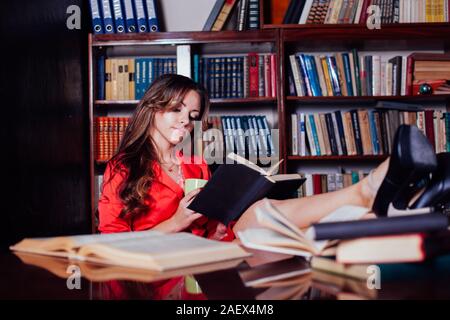 La ragazza si sta preparando per l'esame nella libreria legge libri Foto Stock