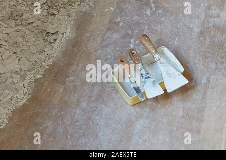 Spatole di gesso e scatole di gesso giacente a terra Foto Stock