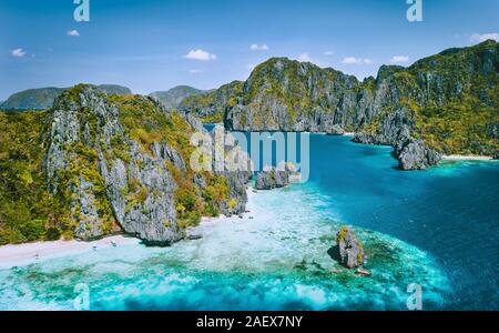 El Nido, PALAWAN FILIPPINE. Vista aerea di isola tropicale con imbarcazioni turistiche ormeggiati alla spiaggia di sabbia bianca. In salmì ambiente carsico stack del mare Foto Stock