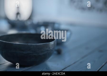 Singing bowls sul pavimento di legno, nei toni del blu. Foto Stock