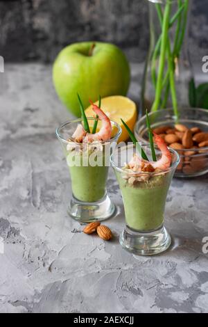 Avocado e mela verde mousse con gamberi e mandorle. Porzione antipasto per un buffet o un banchetto in un bicchiere. Foto Stock