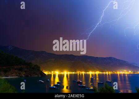 Un fulmine nel cielo notturno sotto Adrasan bay. Adrasan village posizione, Distretto di Kemer, Provincia di Antalya, Turchia. Stile artistico post elaborati pho Foto Stock