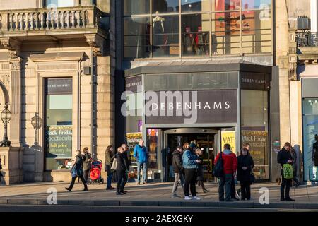 Gli amanti dello shopping al di fuori di entrata al negozio Debenhams su Princes Street di Edimburgo, Scozia, Regno Unito Foto Stock