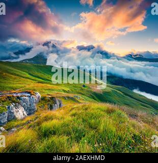 Pochi secondi prima del sorgere del sole nelle nebbiose Val di Fassa con passo Sella. Parco nazionale. Dolomiti, Alto Adige, Italia, Europa. Foto Stock