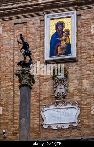 Scultura di San Giorgio che uccide il drago e una lapide per Clemente XI al Palazzo Comunale Foto Stock