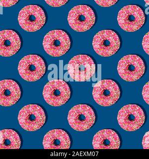 Luminose cibo seamless pattern isometrica con ciambelle.Rosa ciambelle vetrata con zucchero colorato spruzza sul blu classico colore di sfondo.Minimal abstract Foto Stock