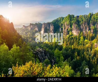 Foschia mattutina sulla scogliera di arenaria nella Svizzera sassone Parco Nazionale. Coloratissima primavera sunrise in Germania, in Sassonia, in Europa. Stile artistico post elaborati Foto Stock