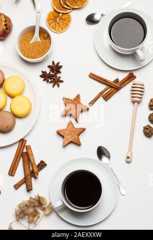 Tazze di caffè e cioccolato e limone macaronson una tavola decorati Foto Stock