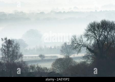 Il gelo e la nebbia su alberi e campi con una vista sulla valle di Rother al South Downs, Dicembre, Tillington, Petworth, Sussex, Regno Unito Foto Stock