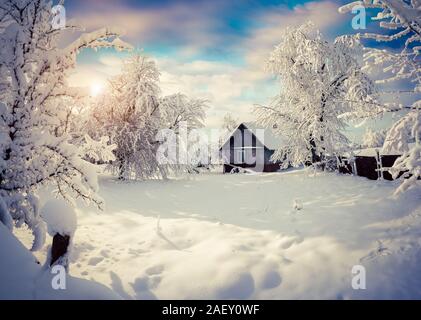 Sunny inverno mattina nel villaggio di montagna dopo la nevicata. Splendida piscina di scena, Felice Anno Nuovo concetto di celebrazione. Stile artistico post pr Foto Stock