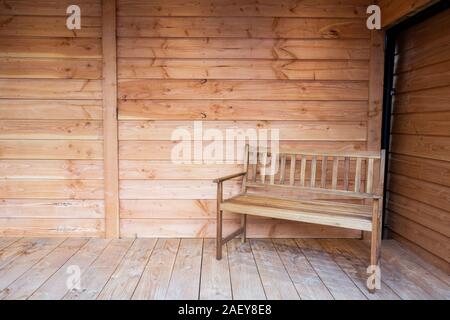 Una panca in legno sedile su una veranda in legno, con tetto in legno close-up nuovi interni moderni Foto Stock