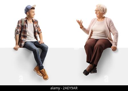 Nonna e nipote seduto su un pannello e parlando isolati su sfondo bianco Foto Stock