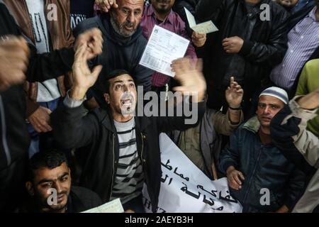 I dimostranti prendere parte a una protesta chiamando SU UN Relief and Works Agency (UNRWA) a pagare i palestinesi per la riparazione delle loro case danneggiate, nella Striscia di Gaza Foto Stock