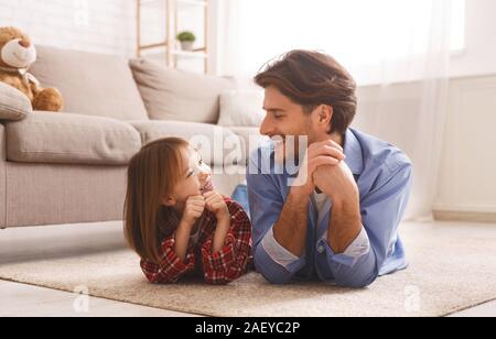 Allegro daddy e la sua figlia po' la posa sul pavimento e guardando ogni altro, consente di divertirsi, arredamento, spazio libero Foto Stock