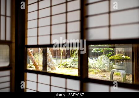 Casa giapponese Onsen ryokan hotel in Giappone con porte scorrevoli di carta shoji e finestra a tradizionale giardino verde Foto Stock