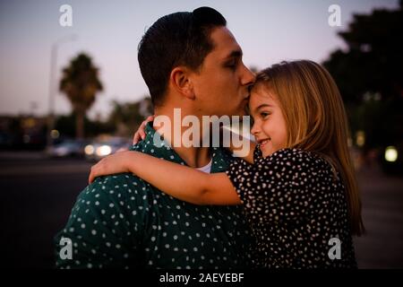 Padre baciare figlia sul fronte Foto Stock