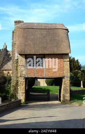 Con il tetto di paglia o Lychgate Lych cancello che conduce al cimitero e Chiesa di San Pietro e San Paolo (c13th) a Long Compton Village Warwickshire England Regno Unito Foto Stock