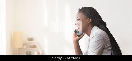 Chiamata telefonica. Sorridente African American imprenditrice parlando al cellulare in ufficio, Panorama con spazio libero Foto Stock
