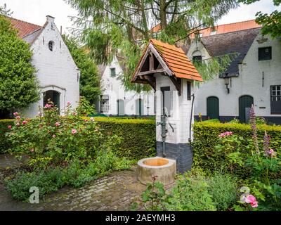 Pompa acqua nel cortile del gli ospizi di carità De Muelenaere, Nieuwe Gentweg, Bruges, Fiandre Occidentali, Belgio Foto Stock