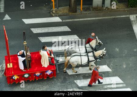 Vista in elevazione della parata medievale durante il famoso White Fiera del Tartufo di Alba con un vagone tirato da cavalli e gli uomini in costume, Cuneo, Piemonte, Italia Foto Stock