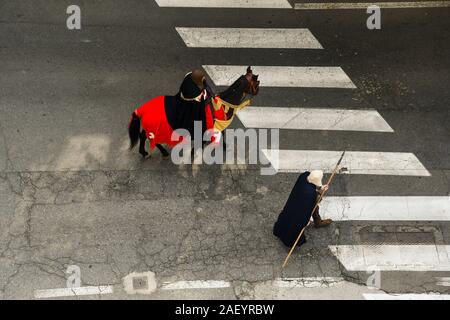 Vista in elevazione di due uomini in costume medievale e una imbrigliato cavallo durante la sfilata del corteo storico del bianco di Alba Fiera del Tartufo, Cuneo, Piemonte, Italia Foto Stock