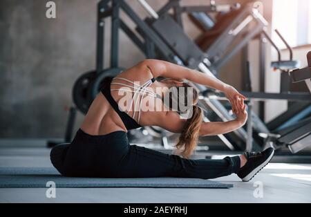 Lo Yoga stretching. Foto di una splendida bionda donna in palestra a suo tempo di fine settimana Foto Stock