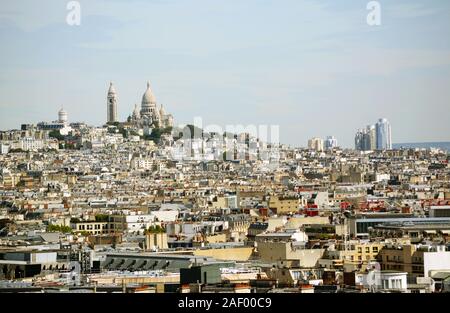 Basilica del Sacre Coeur e Chateau d'eau Montmartre sulla collina, si vede attraverso il territorio densamente edificata Parigi cityscape dalla sommità del Arc de Triomphe Foto Stock