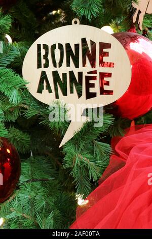 L'immagine verticale di Saluto Anno Nuovo ornamento in francese con il significato di "Buon anno" sull'albero di Natale Foto Stock