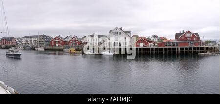 HENNINGSVAER, Norvegia - 13 Luglio 2019: Circolo Polare Artico fjord cityscape del pittoresco villaggio mostra case tradizionali sul terrapieno e barche, shot unde Foto Stock