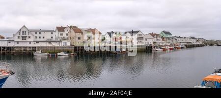 HENNINGSVAER, Norvegia - 13 Luglio 2019: Circolo Polare Artico fjord cityscape del pittoresco villaggio mostra terrapieno con barche da pesca e le tradizionali stilt h Foto Stock