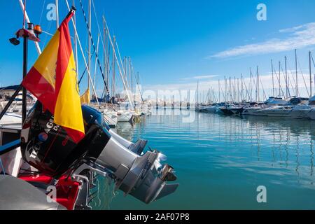 Grande, twin motori fuoribordo sollevata sul retro di una barca in primo piano di un yacht marina in Santa Pola, Spagna. Foto Stock