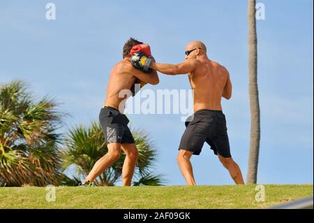 Un Medioevo, montare, maschio boxer training muscolare con personal trainer coach esterno in un parco a Miami Beach, Florida, Stati Uniti d'America Foto Stock