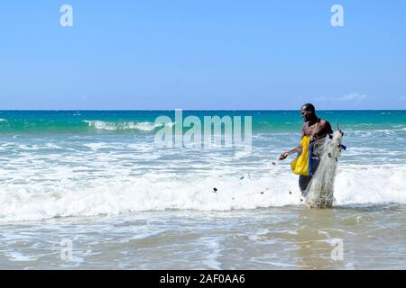 Pescatore africani in acqua poco profonda con la sua rete da pesca Foto Stock