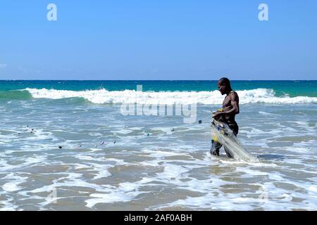 Pescatore africani in acqua poco profonda con la sua rete da pesca Foto Stock