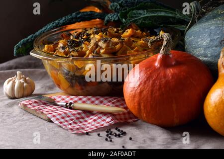 Casseruola di zucca. Un sano e delizioso cibo fatto da prodotti organici. Accanto alla tabella sono zucche, aglio e Kale. Foto Stock