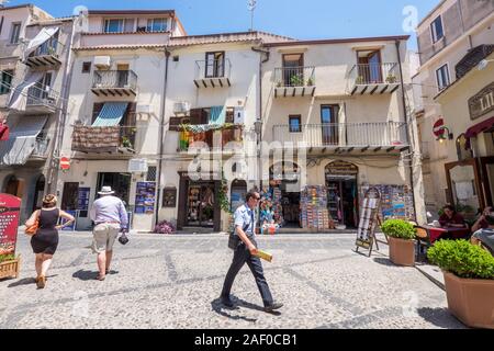 Postino consegna posta nel centro storico di Cefalù, in Sicilia. La storica Cefalù è una delle principali mete turistiche della Sicilia. Foto Stock