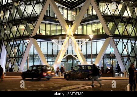 Stella di natale decorazione e taxi fuori dall'entrata del grattacielo gherkin edificio nel quartiere finanziario della città di Londra UK KATHY DEWITT Foto Stock