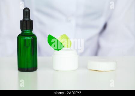 Olio biologico acidificazione. La donna lavora presso il laboratorio di produzione cosmetici.Private piccoli prodotti cosmetici in fabbrica. Giovane tecnologo rendendo la faccia Foto Stock