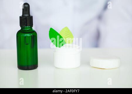 Olio biologico acidificazione. La donna lavora presso il laboratorio di produzione cosmetici.Private piccoli prodotti cosmetici in fabbrica. Giovane tecnologo rendendo la faccia Foto Stock