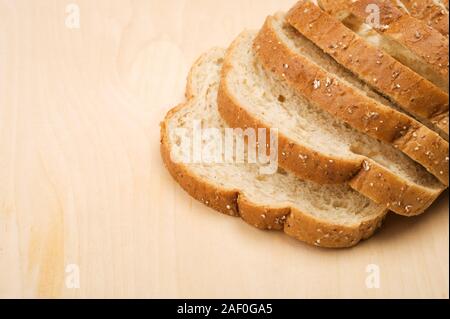 Fette di pane bianco su sfondo di legno. Foto Stock